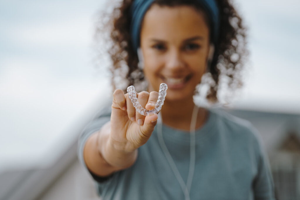 a girl holding clear aligners